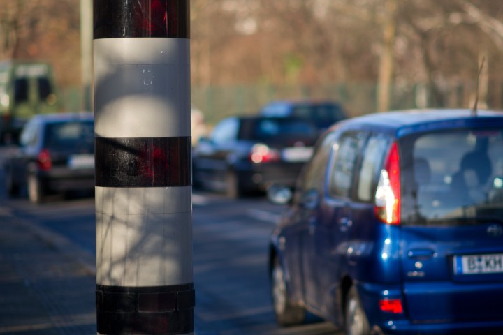 BlitzersÃ¤ule und ein vorbeifahrendes Auto