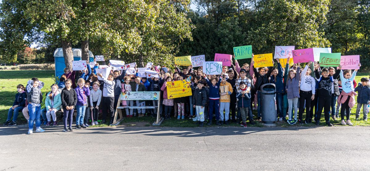 Kinder demonstrieren mit Plakaten am Salzgittersee vor einer Kinderbank