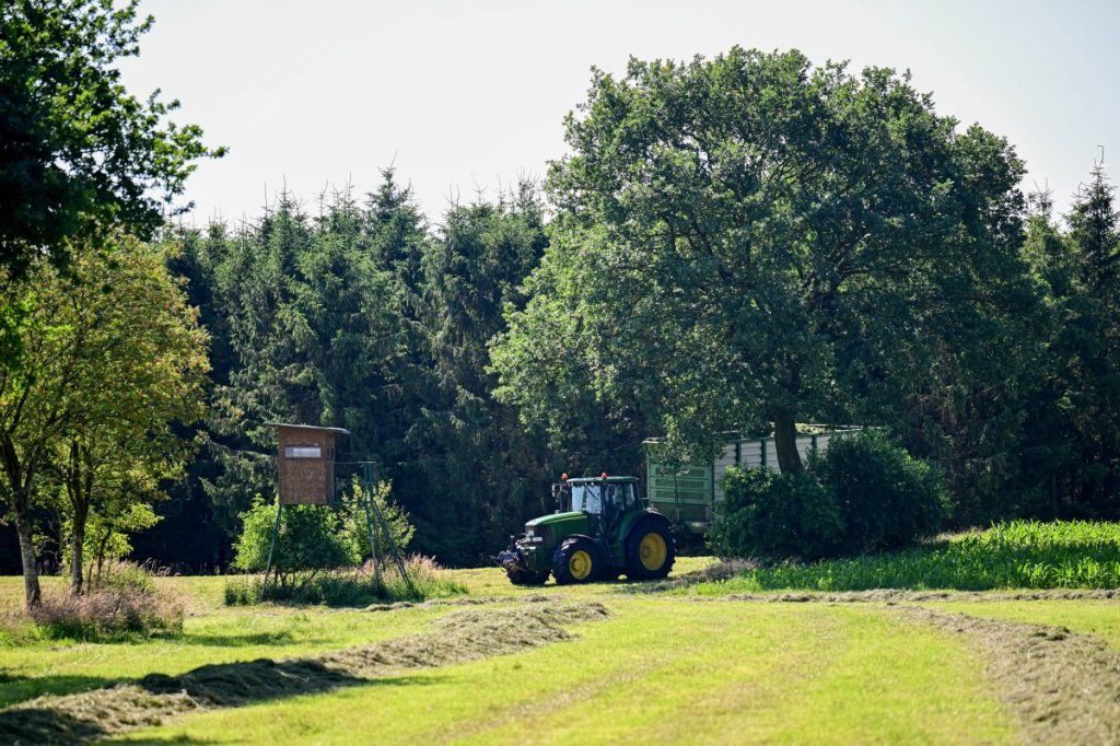 Ein Landwirt fährt mit einem Traktor über eine Wiese nahe des Fundortes einer Kinderleiche.