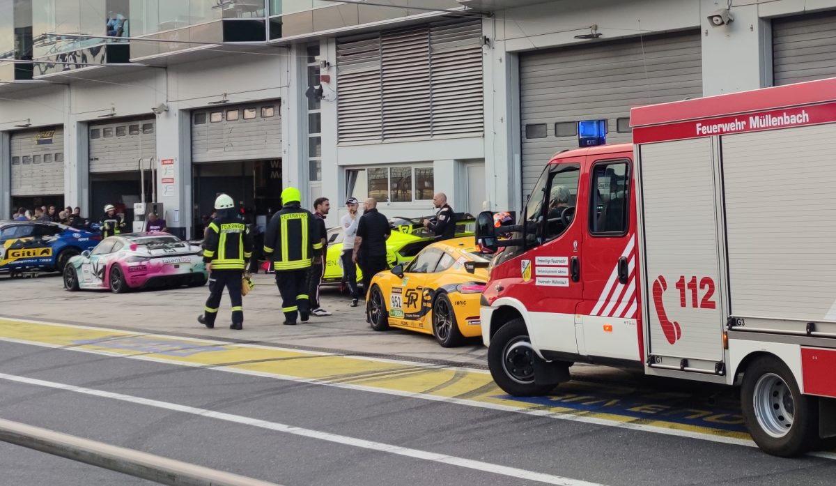 Nürburgring: Feuerwehrleute laufen vor Box 27 in der Boxengasse. Bei der Explosion einer Druckluftflasche hinter der Box im Bereich des Fahrerlagers wurden etliche Menschen verletzt.