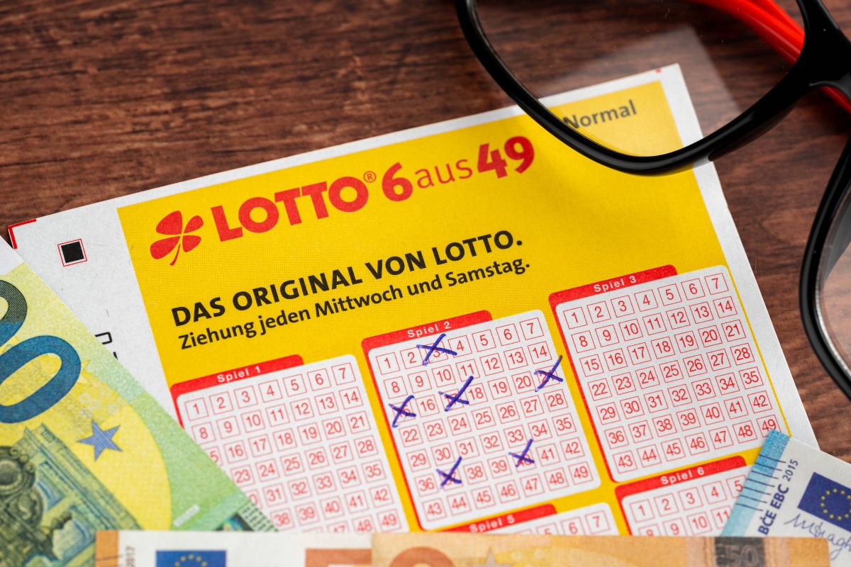 Lottoschein von Lotto 6 aus 49 mit ausgefüllten Tippfeldern und Euro Geldscheinen