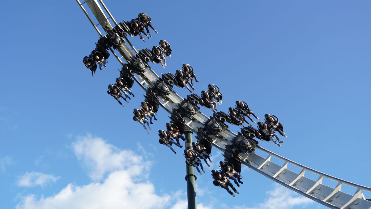 Mehrere Menschen haben SpaÃŸ auf einem FahrgeschÃ¤ft im Heide Park bei blauem Himmel (Symbolbild)